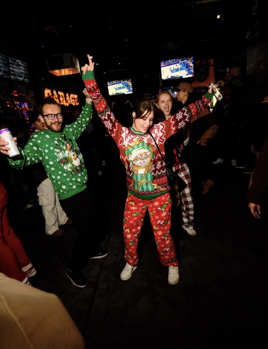 Someone dancing in the middle of the bar in Christmas pyjamas, arms up, the room going with them